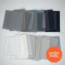 Array of small pieces of grey solid colored fabrics spread out randomly. 