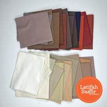 Array of small pieces of tan and brown solid colored fabrics spread out randomly. 